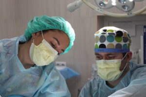 Two surgeons with masks on performing gastric sleeve surgery